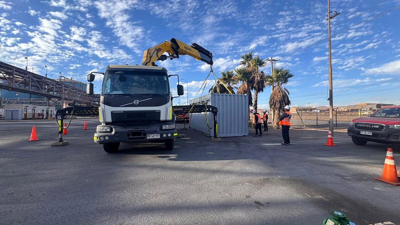 Camión pluma en operación de patio. Apoyo logístico y operacional en patio industrial.