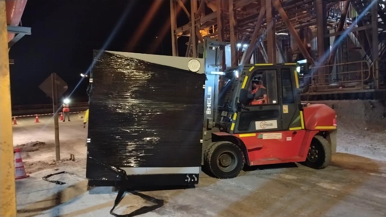 Movimiento de carga con grúa horquilla. Operación nocturna de carga y posicionamiento con grúa horquilla.