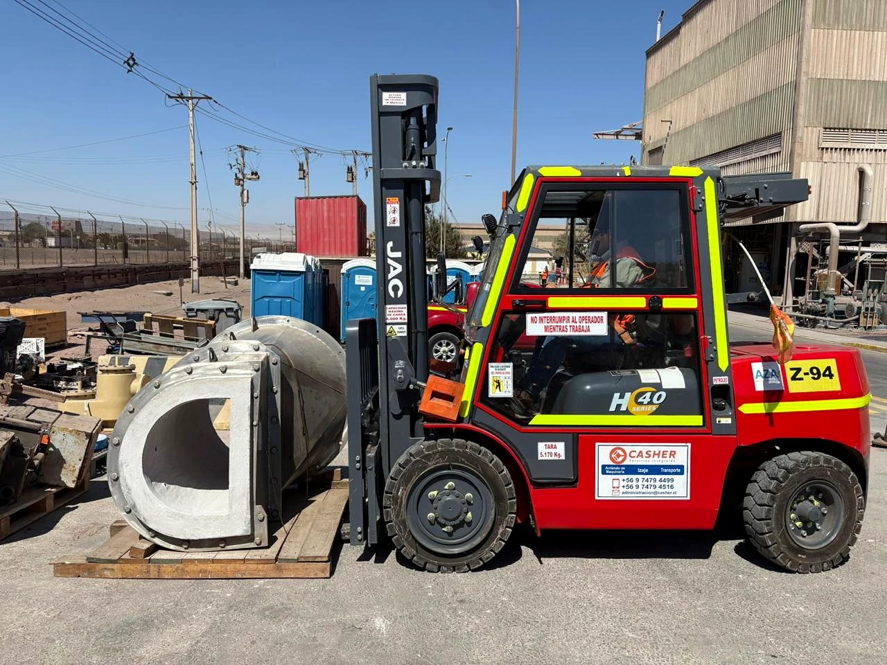 Grúa horquilla en patio industrial. Equipo de grúa horquilla preparado para maniobras de apoyo operacional.