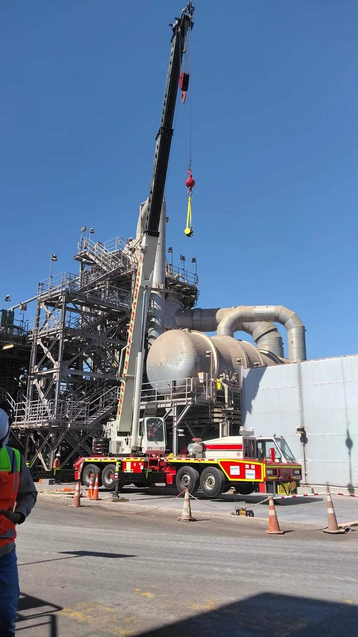 Grúa telescópica en planta. Grúa telescópica operando en una instalación industrial de alta complejidad.